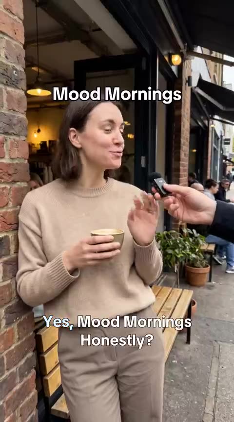 Woman with a coffee outside a London café talking about Mood Mornings